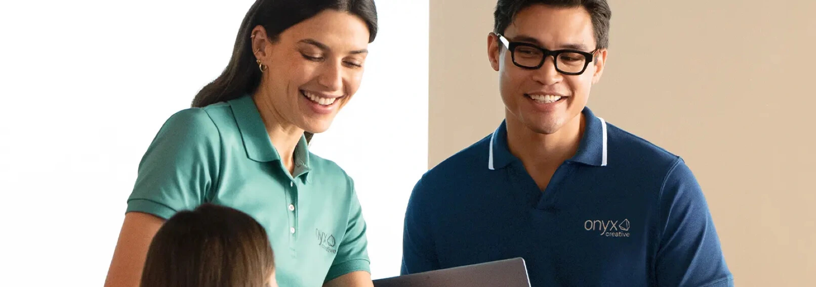 Smiling coworkers wearing branded OEKO-TEX Standard 100 polo shirts