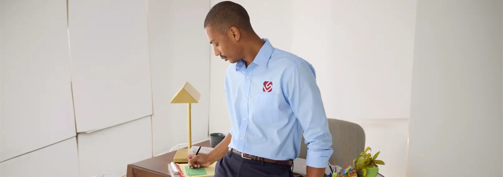 Corporate employee wearing a branded button-down shirt at desk.