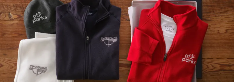 Collection of branded fleece jackets and shirts for corporate events.