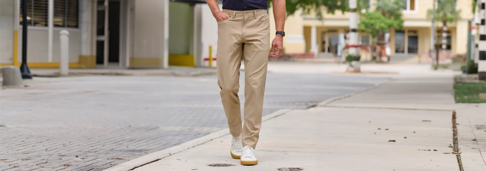 Man wearing lightweight khaki performance chino pants on a city street.
