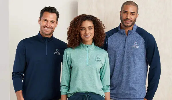 Two sailboats pass by a lighthouse on the coast.