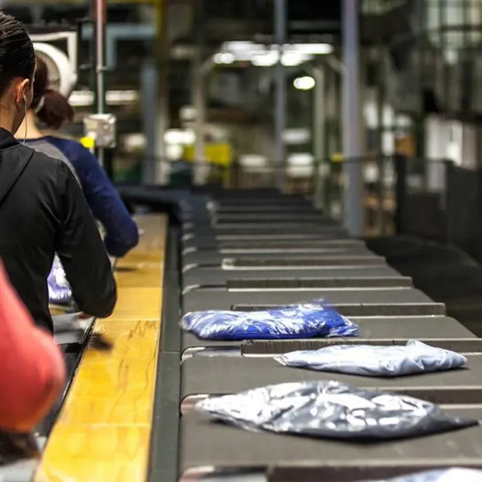 Packaged clothing moving on a conveyor belt in a distribution center.