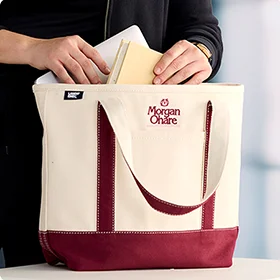 An employee using an embroidered canvas tote bag.