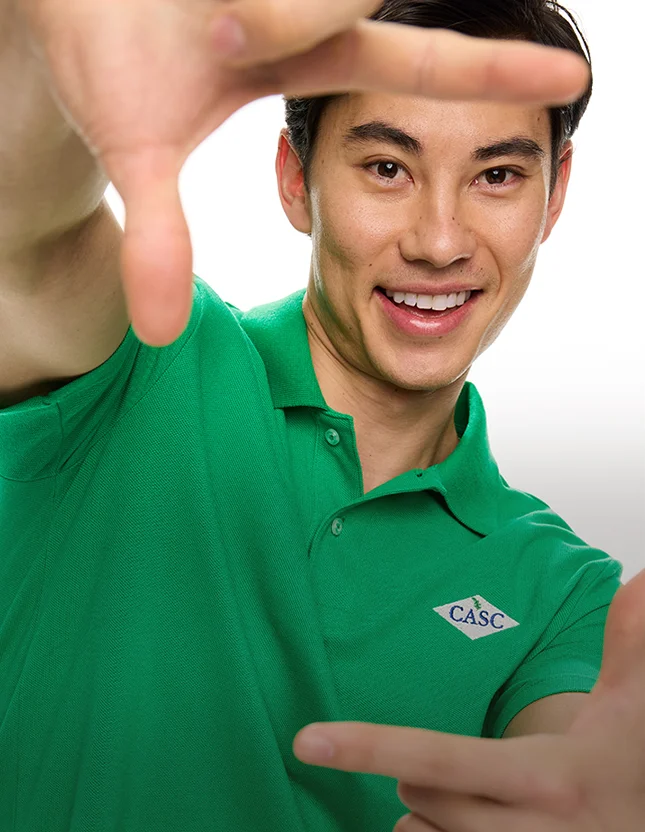 Man wearing a green essential pique polo.