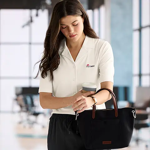 A woman wearing a white texture polo with black performance bottoms.