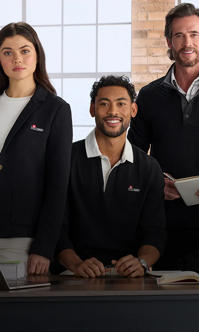 Employees wearing black embroidered jackets and white shirts.