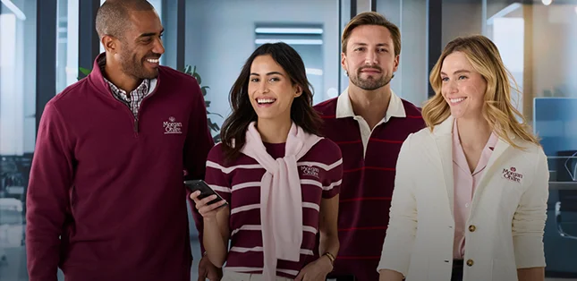 Four employees wearing burgundy and white embroidered apparel.