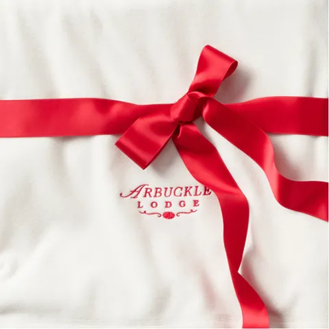 A white fleece with a red ribbon tied around it.