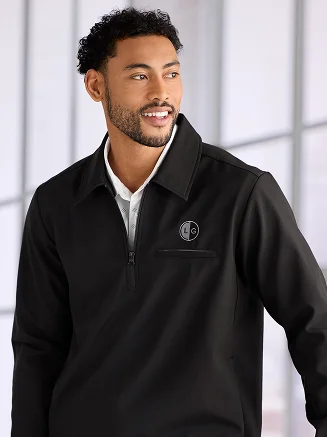 Man wearing a black monogrammed quarter zip.