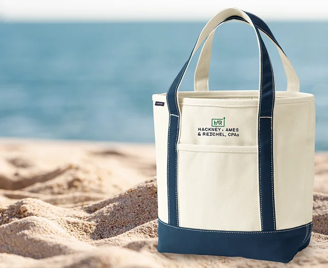 Monogrammed canvas tote sitting on a beach