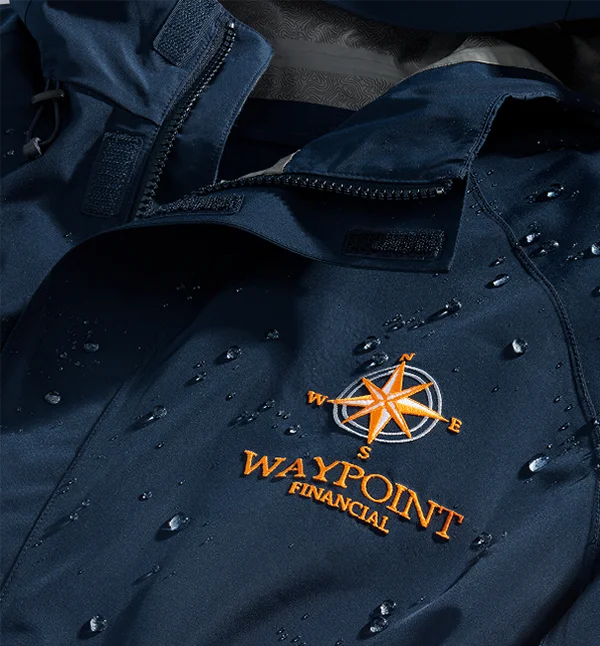 Close-up image of a navy rain jacket with a custom monogram