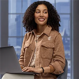 A woman wearing a brown fleece shirt jacket.