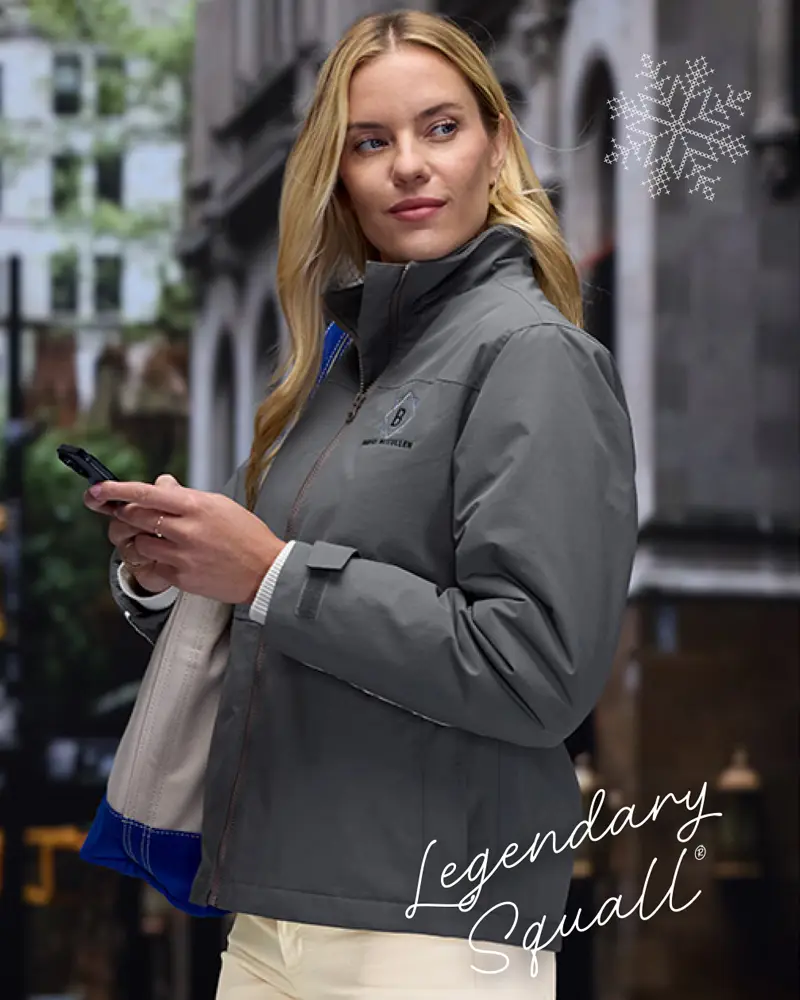 Legendary Squall - A woman wearing a gray jacket with a tote on her shoulder texting on her phone.