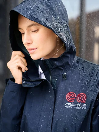 Woman wearing a navy monogrammed rain jacket.