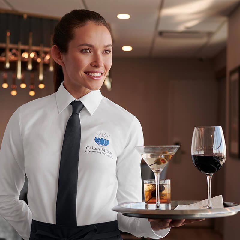 A waitress serves cocktails to a table.